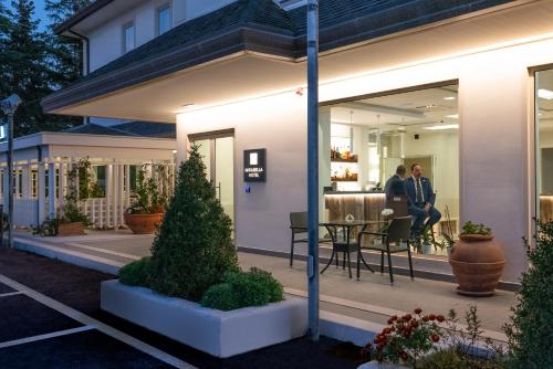 two people sitting on a porch of a house at Mirabella Hotel in Mirabella Eclano
