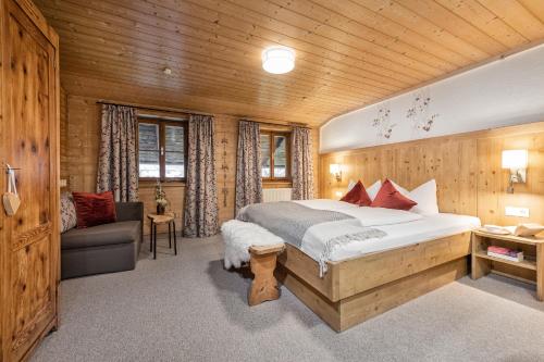 a bedroom with a large bed and a couch at Ferienwohnung Schustererhof in Stumm