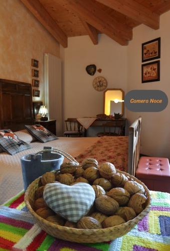 a room with a bed with a basket of coconuts at Villa Amaranta Room and Breakfast in Edolo