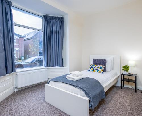 a bedroom with a bed and a large window at Relaxing Retreat Perfect For Longer Stays in Southampton