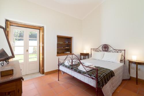 1 dormitorio con 1 cama, TV y puerta en Casa de S. Paio - 3 bedroom villa w/ pool & garden, en Braga