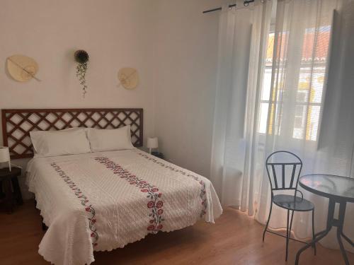 a bedroom with a bed and a table and a window at Avis Guesthouse in Évora