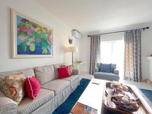 ein Wohnzimmer mit einem Sofa und einem Tisch in der Unterkunft Meia Praia Beach Apartment - Penthouse com vista panorâmica para o oceano in Lagos