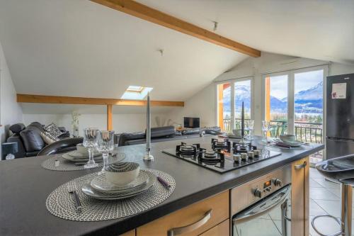 une cuisine avec un comptoir avec une cuisinière dans l'établissement Cabana & Panorama Lac Annecy -Parking & Terrasse, à Sévrier