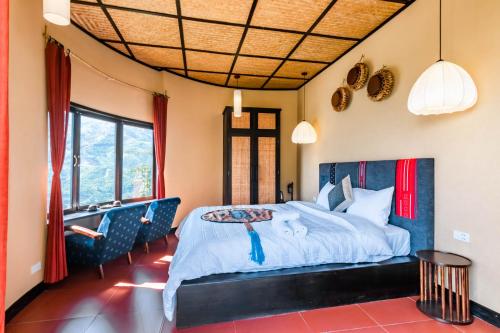 a bedroom with a large bed with blue chairs at Sapa Farmstay in Sapa