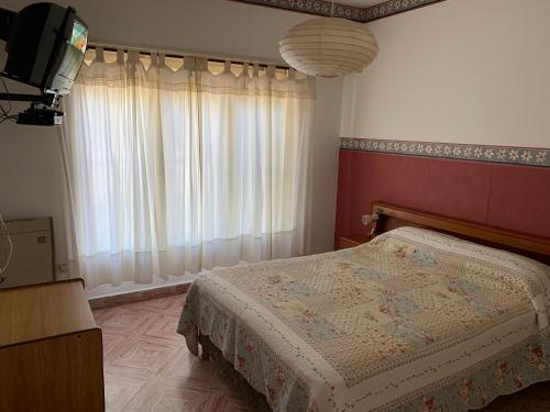 a bedroom with a bed and a television in it at Chalet para 4 in Miramar