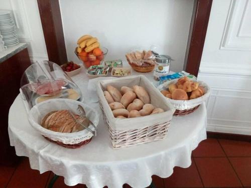 a table with baskets of bread and other foods on it at Hotel Santa Comba in Moura