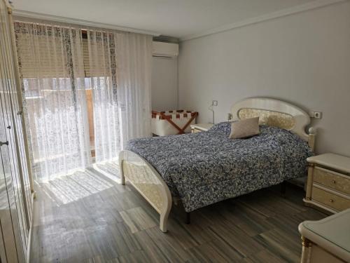 Un dormitorio con una cama y una ventana grande. en Ático Primera Línea Parque de Elche, en Benidorm