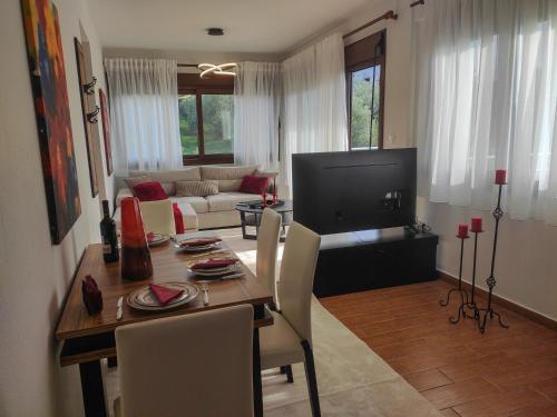 a living room with a dining table and a television at Kashmir Luxury Apartments in Neos Marmaras