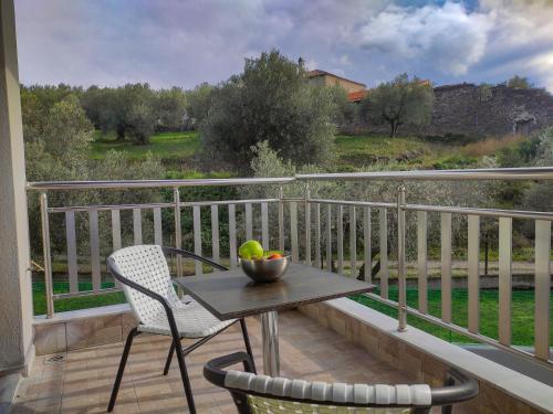 a table with a bowl of fruit on a balcony at Kashmir Luxury Apartments in Neos Marmaras
