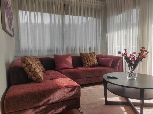 a living room with a red couch and a table at Kashmir Luxury Apartments in Neos Marmaras