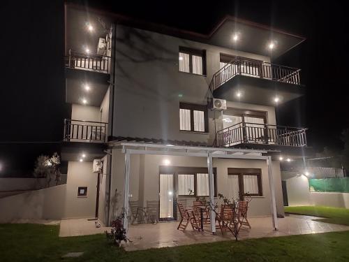 a building with chairs and tables in front of it at night at Kashmir Luxury Apartments in Neos Marmaras