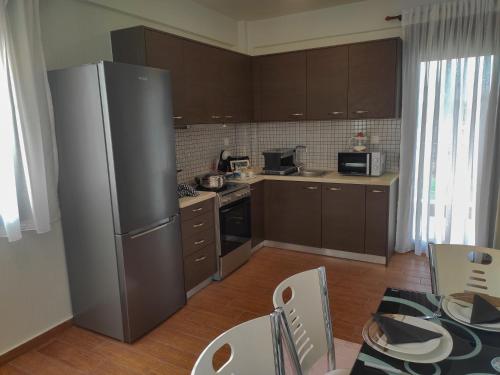 a kitchen with a refrigerator and a table and chairs at Kashmir Luxury Apartments in Neos Marmaras