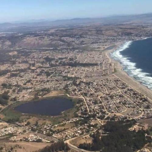 eine Luftansicht auf eine Stadt und das Meer in der Unterkunft Cabañas Pino, Un lindo lugar de descanso -playa I in Las Cruces