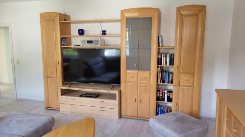 a living room with a television and a book shelf at Ferienwohnung Malbergblick klassifiziert mit 4 DTV-Sternen in Bad Ems