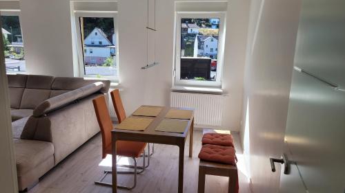 sala de estar con mesa y sofá en Ferienwohnung Malbergblick klassifiziert mit 4 DTV-Sternen en Bad Ems