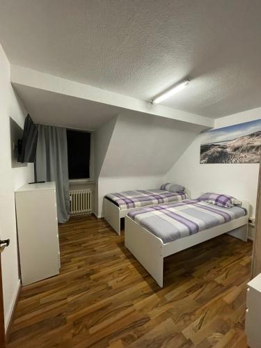 a room with two beds and a tv in it at Monteur Wohnung für 4 Personen in Oberhausen. in Oberhausen