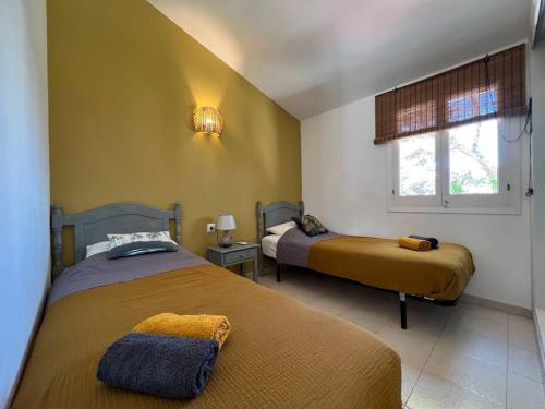 una camera con due letti e una finestra di Lulu Menorca Modern apartment 300m from Cala Blanca beach a Cala Blanca