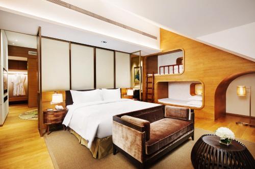 ChongliにあるHoliday Inn Resort Zhangjiakou Chongli, an IHG Hotelのベッドとソファ付きのホテルルーム