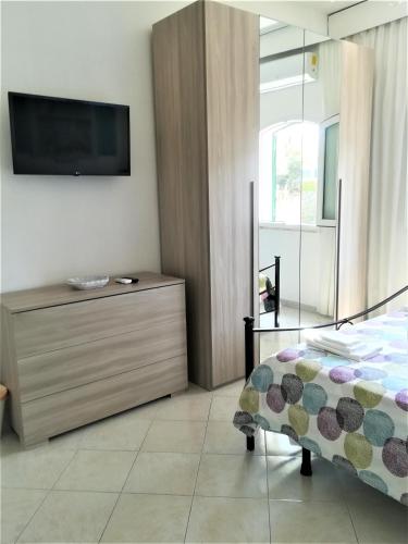 a bedroom with a bed and a tv on a wall at Casa Malo' in Ischia