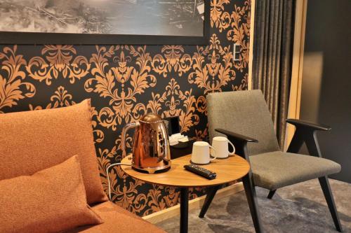 a tea kettle on a table next to a chair at Hotel Brandan in Tórshavn