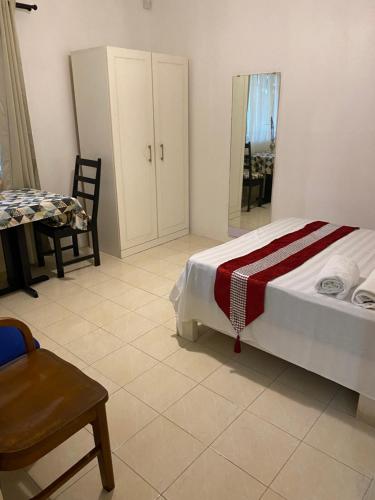 a bedroom with a bed and a chair and a mirror at Gardenia Apartments in Pereybere