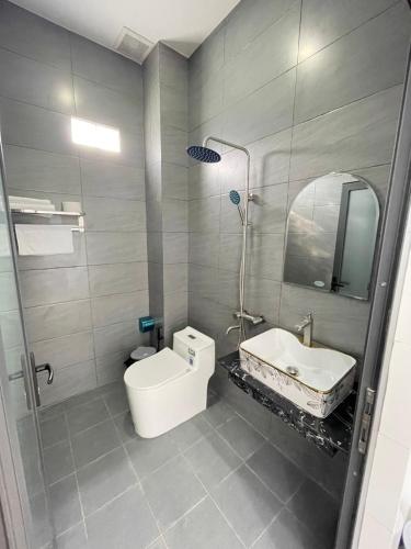 a bathroom with a sink and a toilet and a mirror at Nhà nghỉ Quỳnh Như in Cao Lãnh