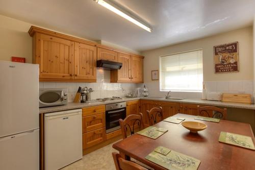 cocina con armarios de madera y mesa de madera con mesa de madera en The Albany Apartments, en St. Peter Port