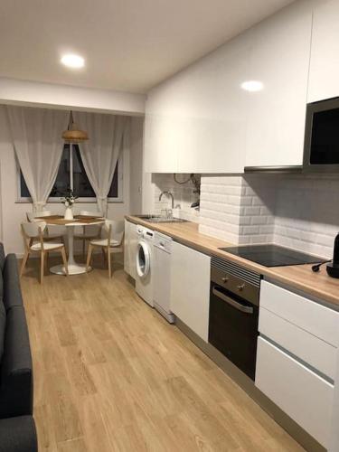 a kitchen with a table and a dining room at Apartamento T2 Montegordo a 500 m da praia in Monte Gordo