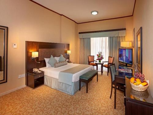 a large hotel room with a bed and a television at Chelsea Gardens Hotel Apartment in Dubai