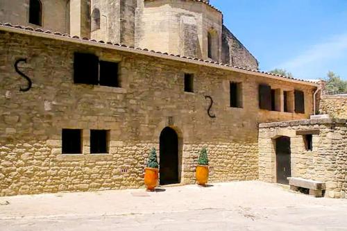 duży ceglany budynek z wieżą na górze w obiekcie Gite en Provence proche Avignon w mieście Sauveterre