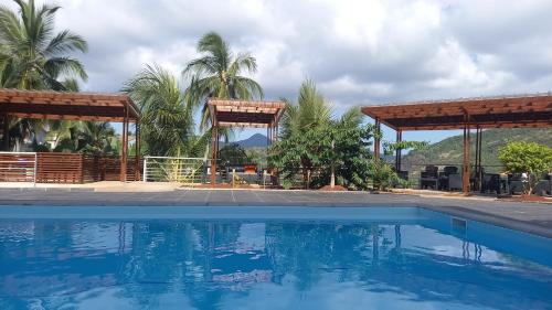 a swimming pool in front of a house with trees at TSINGONI VILLAGE Meublé de Tourisme in Tsingoni