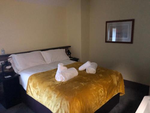 a hotel room with a bed with towels on it at THE KINGS ARMS INN in Stratton