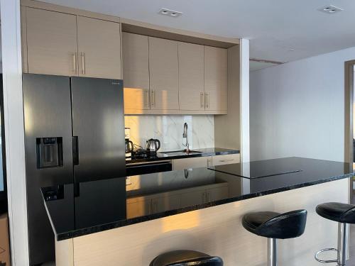 a kitchen with black and white cabinets and stools at Modern villa - in Golden Circle - Gullfoss Geysir Þingvöllur - Freyjustíg 13, 805 Selfoss in Búrfell