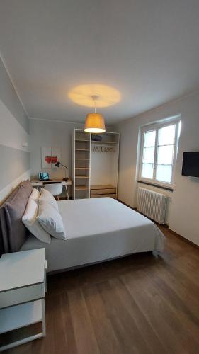 a bedroom with a large white bed and a desk at Agriturismo Tenuta Valletti. in Sesta Godano