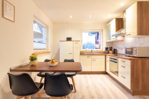a kitchen with a wooden table and black chairs at Haus Hanni Zarrentin am Schaalsee in Zarrentin