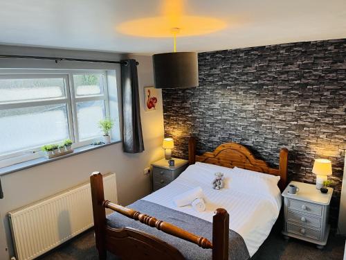 um quarto com uma cama e uma parede de tijolos em The Lake View Hotel em Llanberis