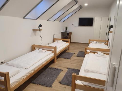 a dorm room with three beds and a skylight at Breier Farm - Tanya Panzió in Pomáz