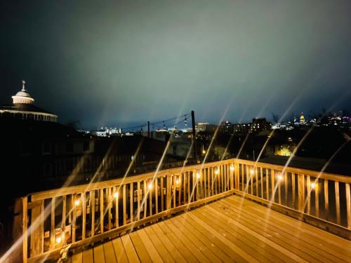 eine hölzerne Promenade mit Lichtern in der Nacht in der Unterkunft Cozy home with rooftop deck-downtown baltimore in Baltimore