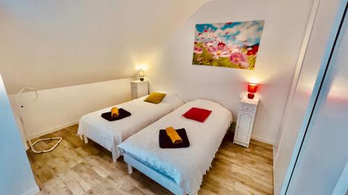 pokój z dwoma łóżkami i obrazem na ścianie w obiekcie Kerhos - appartement vue mer w mieście Camaret-sur-Mer