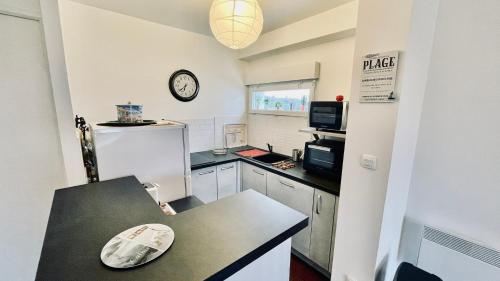 une cuisine avec un réfrigérateur blanc et un plan de travail dans l'établissement Kerhos - appartement vue mer, à Camaret-sur-Mer