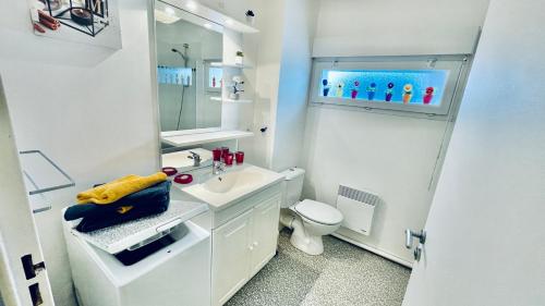 biała łazienka z umywalką i toaletą w obiekcie Kerhos - appartement vue mer w mieście Camaret-sur-Mer