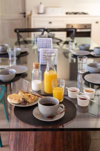 a table with a plate of food and a cup of orange juice at Casa Solcor Boutique Bed & Breakfast in San Pedro de Atacama