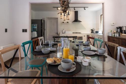 a dining room with a glass table with food on it at Casa Solcor Boutique Bed & Breakfast in San Pedro de Atacama