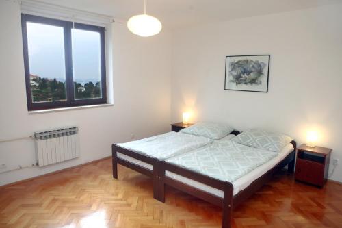 een slaapkamer met een bed en twee nachtkastjes bij Warm and Comfy Piran Apartment with Parking! in Piran