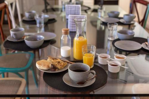 a glass table with plates of food and orange juice at Casa Solcor Boutique Bed & Breakfast in San Pedro de Atacama