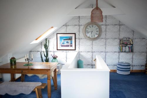 a room with a table and a clock on a wall at The Sail Loft in Kingsbridge