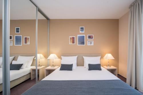 a bedroom with a large bed and two lamps at Hotel Zlatna Vala in Umag