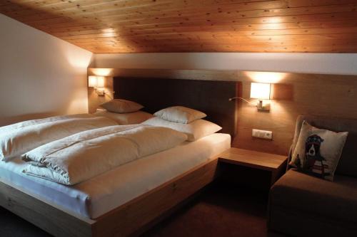 レッヒにあるHaus Biberkopfの木製天井の客室の大型ベッド1台分です。