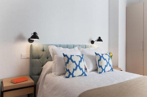 um quarto com uma cama com almofadas azuis e brancas em Cozy apartment in the center of Madrid em Madri